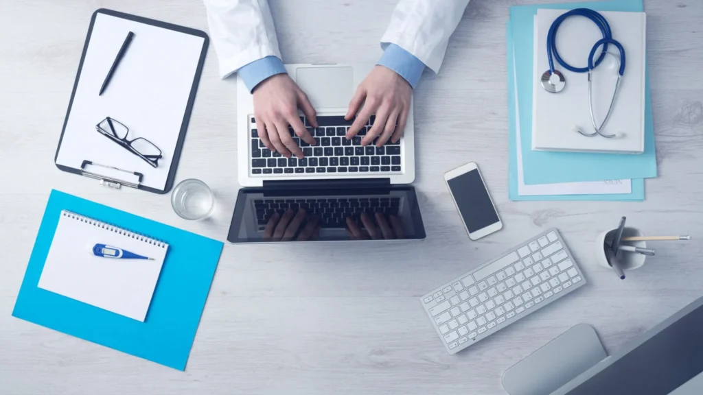 Person typing on laptop with organized items beside, promoting fast payment processing with PMR Medical Billing Services
